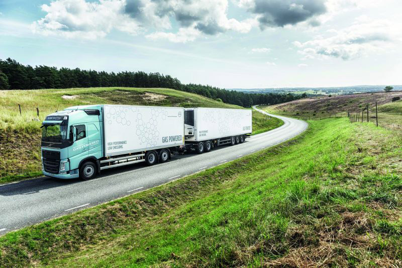 Schwertransport auf einer Landstraße, mitten im Grünen (Lkw mit alternativen Antrieben)